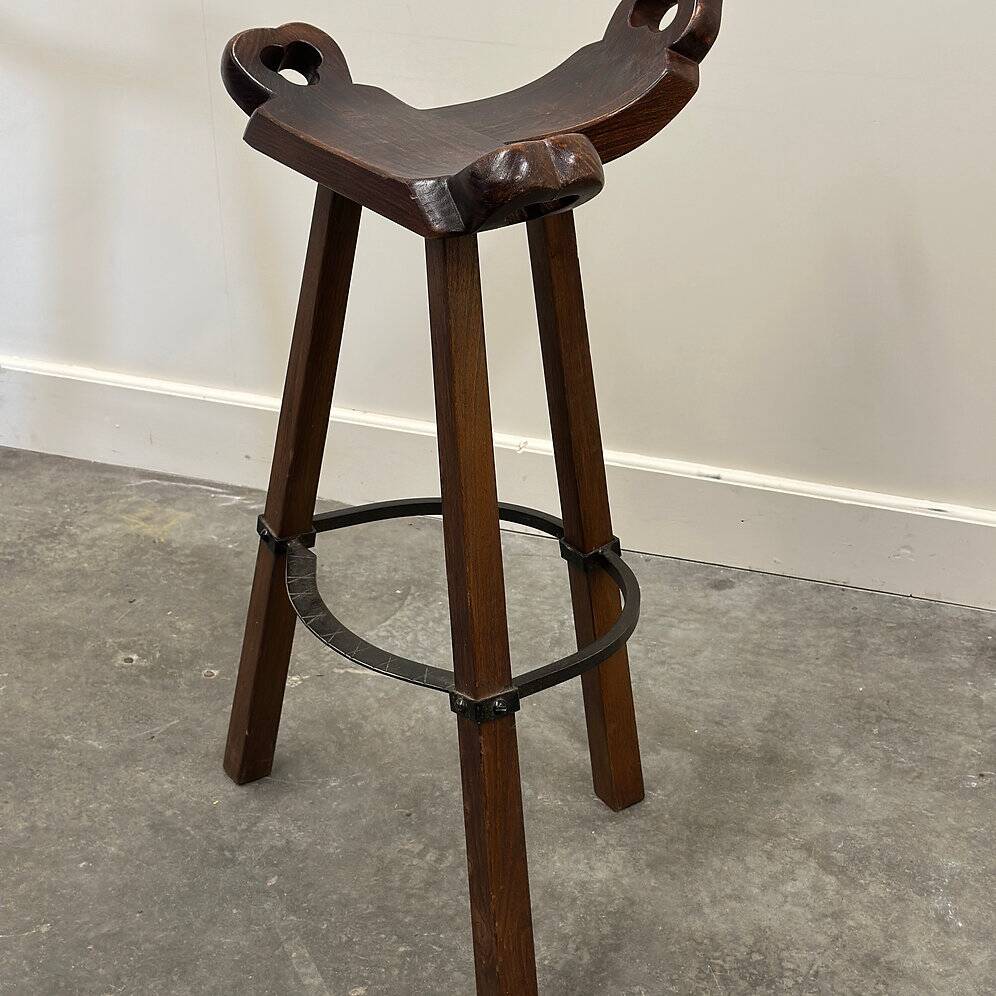 Set of 3 rustic carved oak bar stools with iron footrests, 1970s