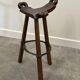 Set of 3 rustic carved oak bar stools with iron footrests, 1970s