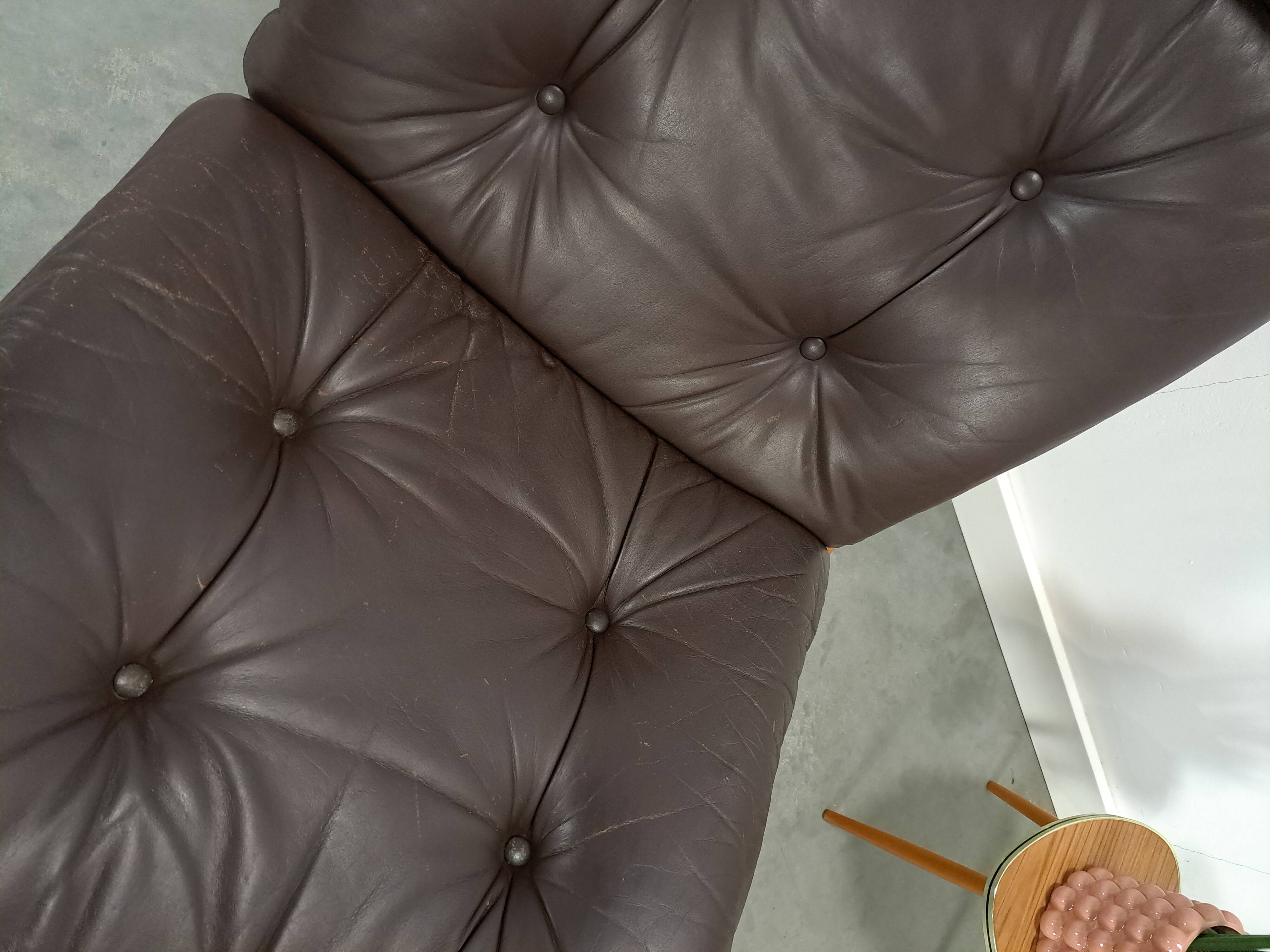 Bruin leren fauteuil met houten onderstel