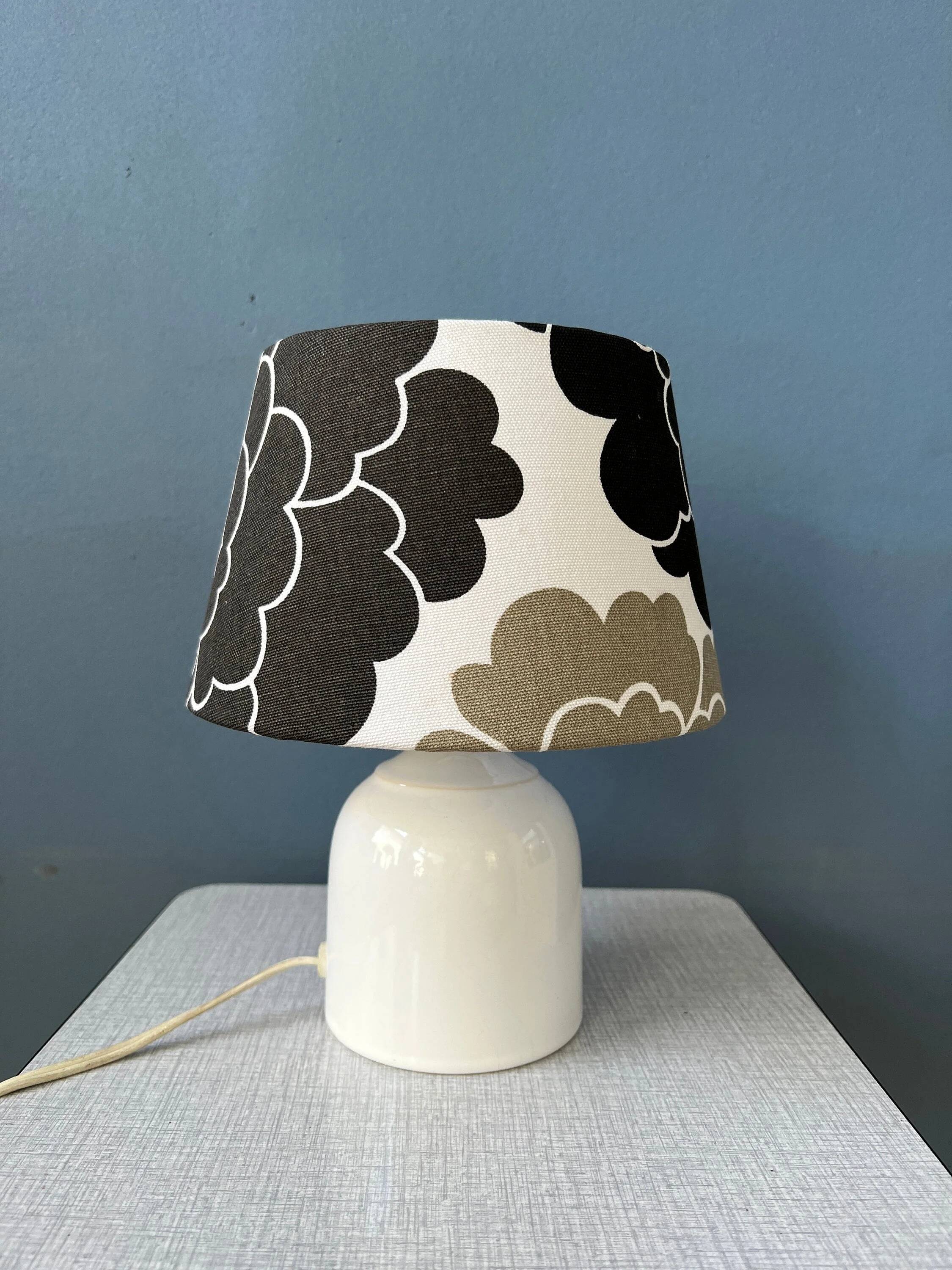 Small Space Age table lamp with a porcelain base and black and white flower shade.