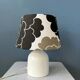 Small Space Age table lamp with a porcelain base and black and white flower shade.