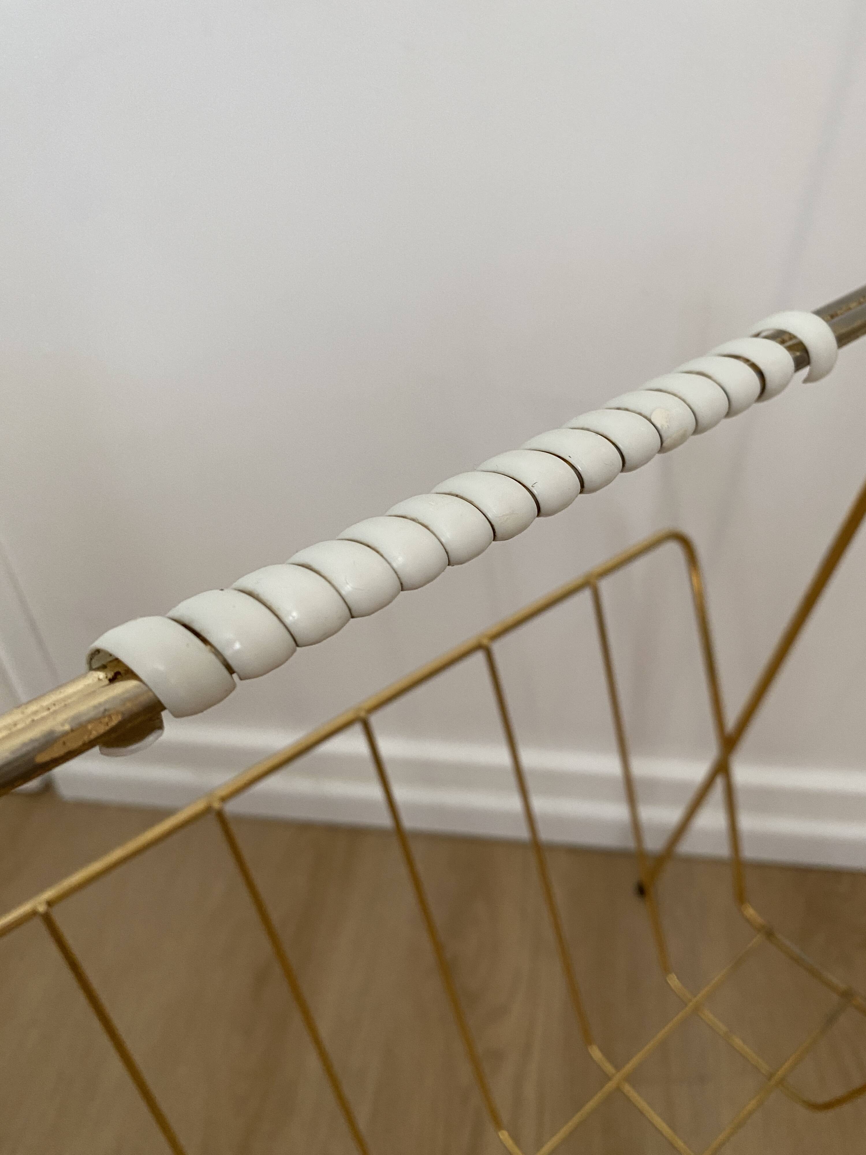 Vintage magazine rack in gold metal with white plastic handle. 60s.