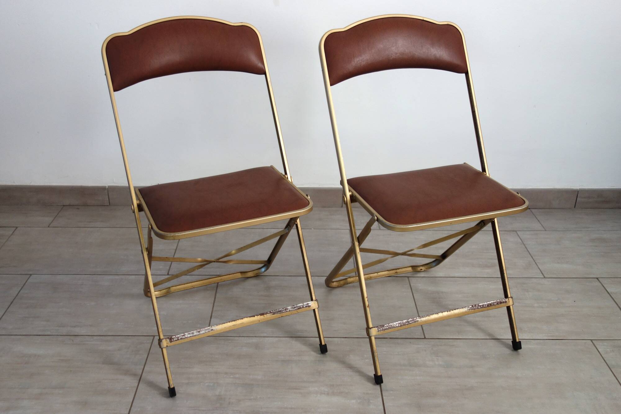2 golden metal chairs with faux leather in the 60s/70s Opera style.