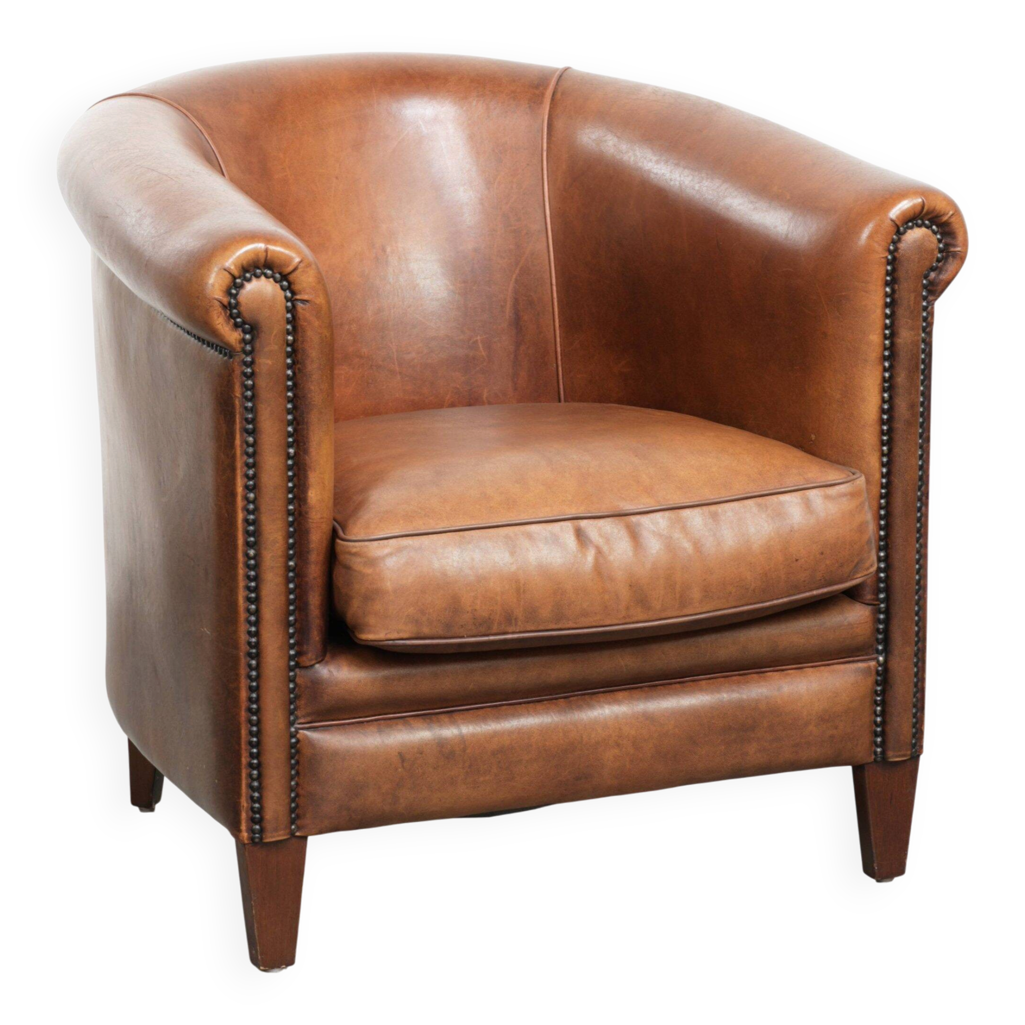Sheepskin club armchair with a cognac colour finished with decorative nails