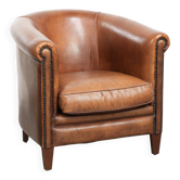 Sheepskin club armchair with a cognac colour finished with decorative nails