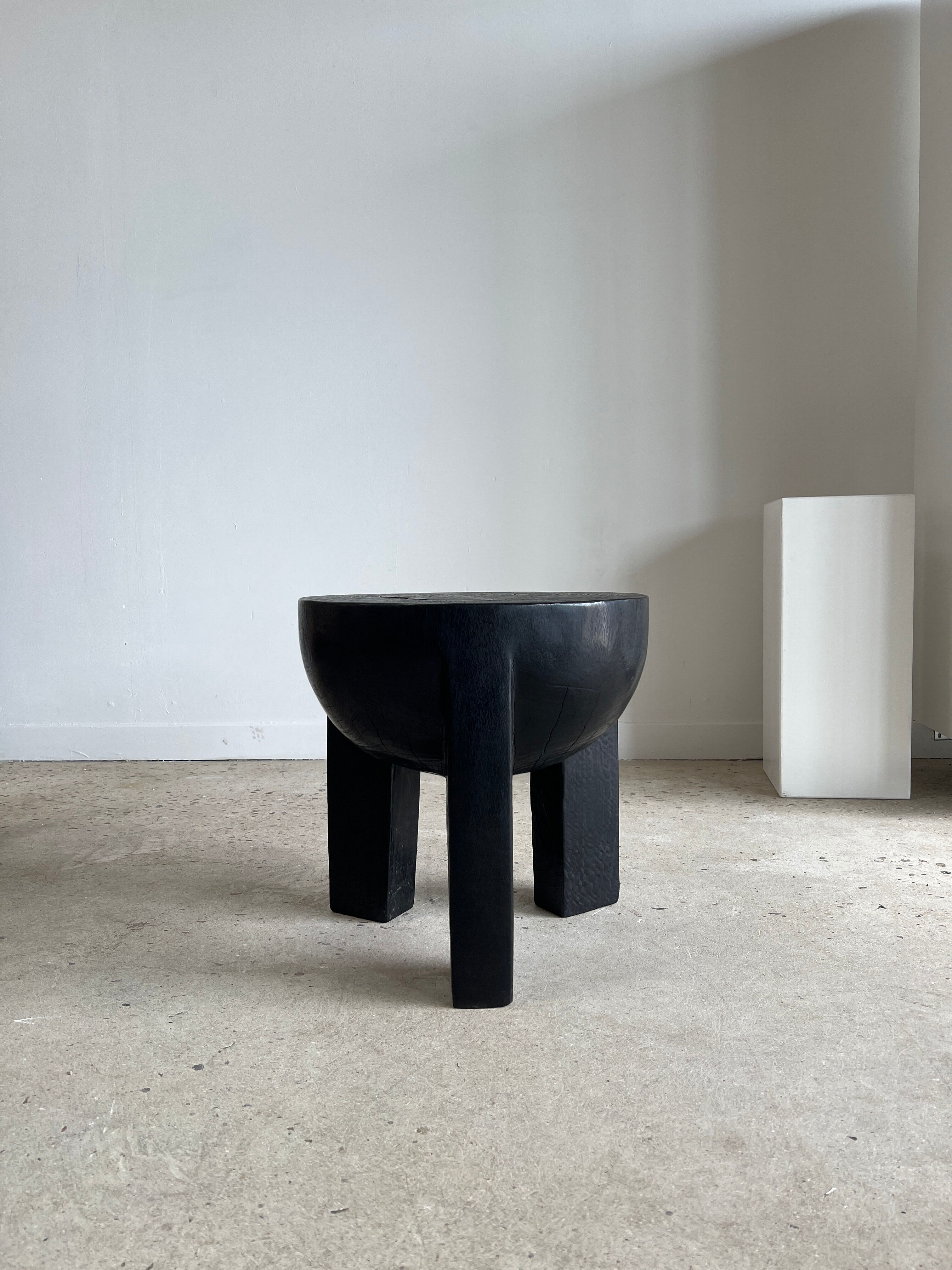 Black mango wood tripod side table with a semi-spherical top, height: 45 cm, diameter: 44 cm.