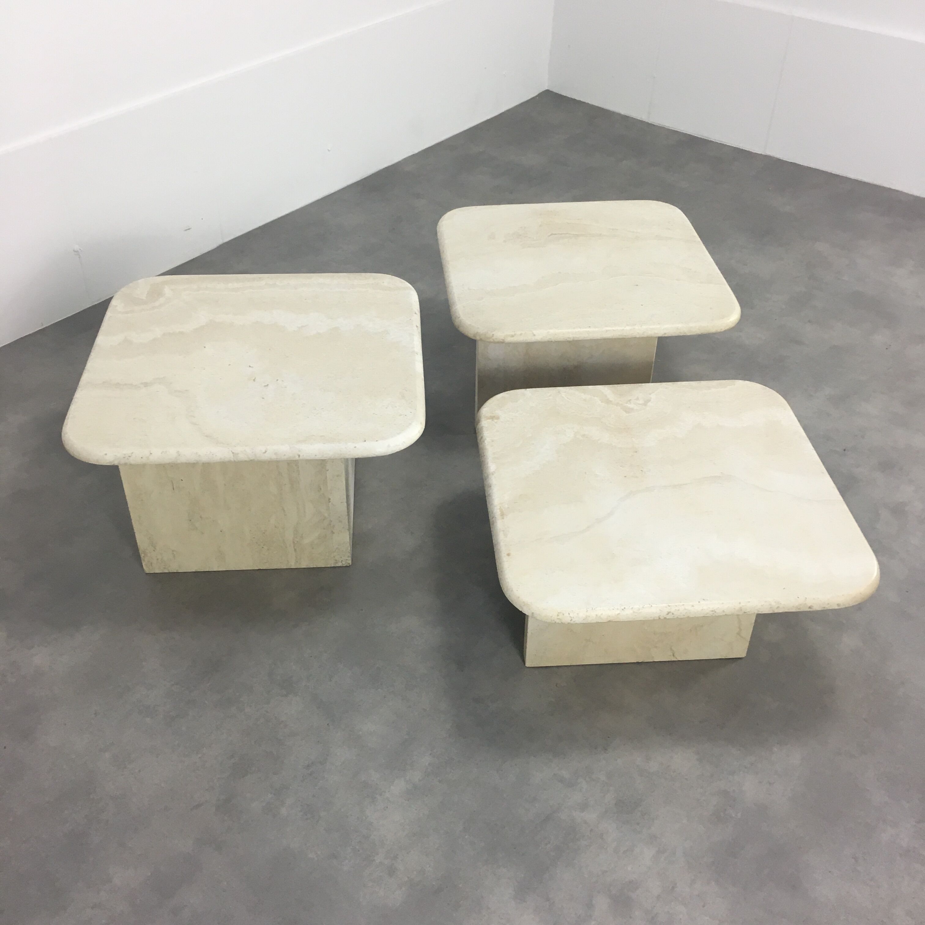 Three travertine trundle coffee tables
