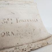 Bust of woman in plaster on pedestal with inscription