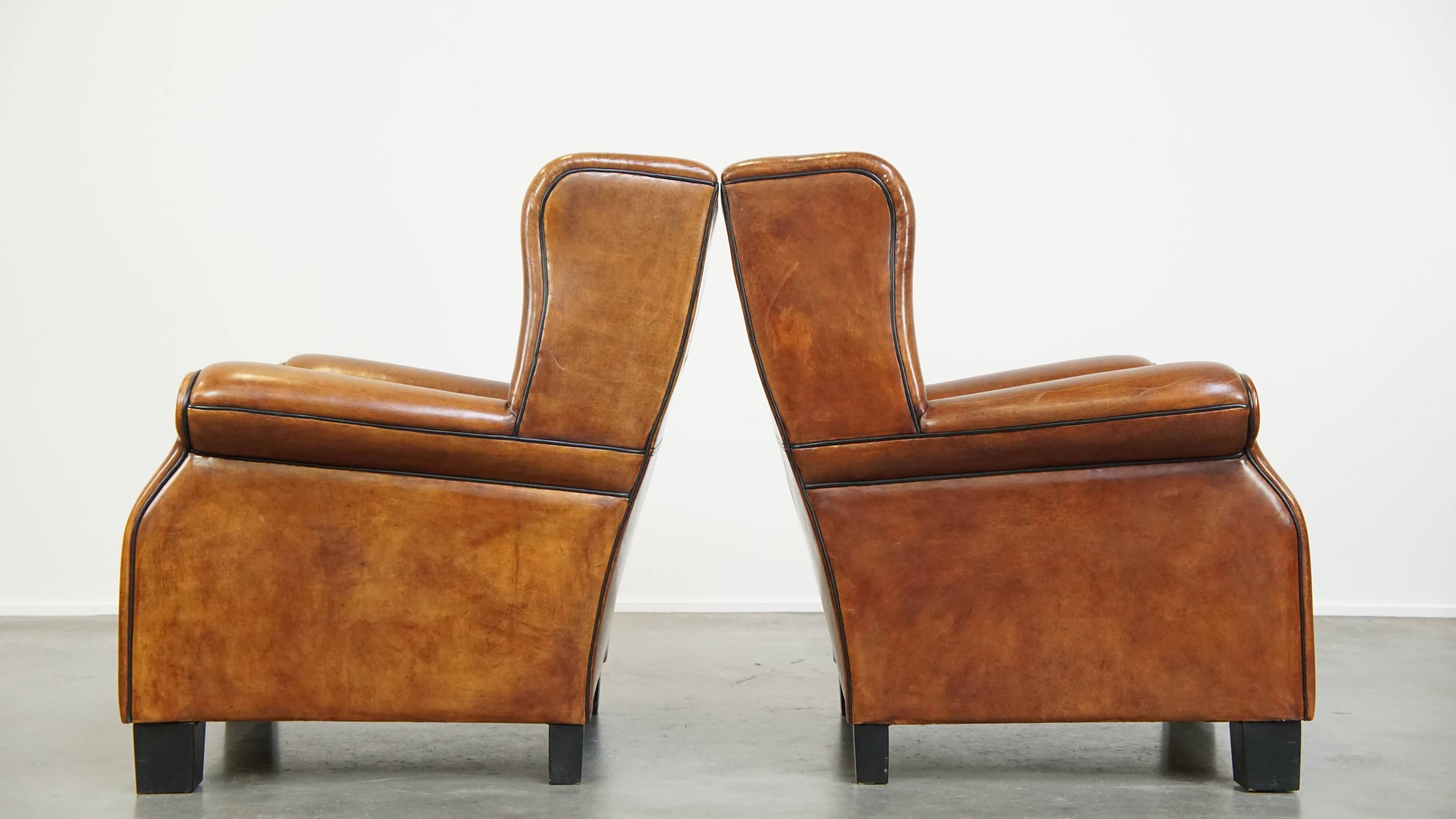 Set of 2 very comfortable large sheepskin armchairs elegantly finished with black piping