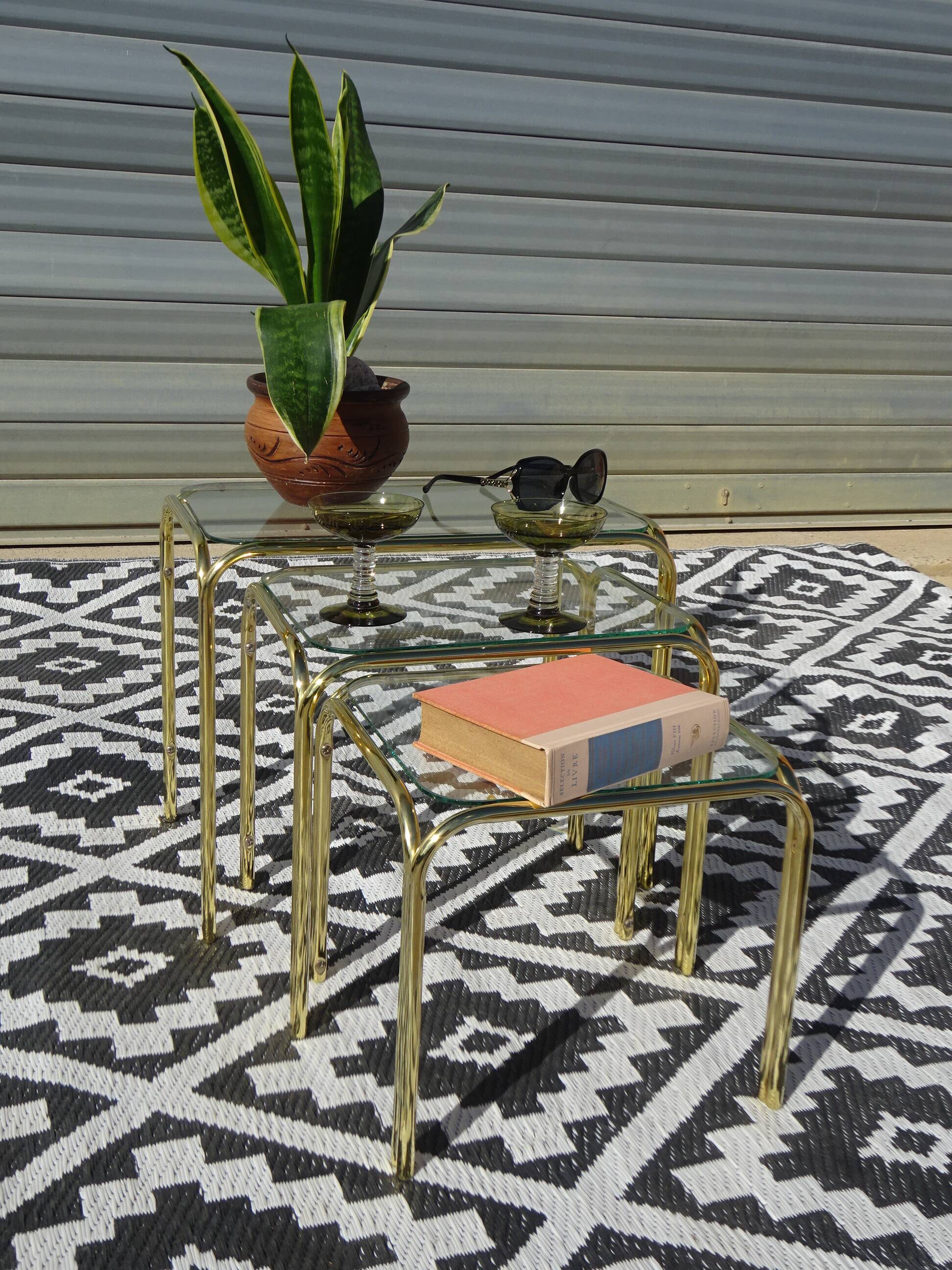 Nested tubular tables in gold metal.