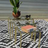 Nested tubular tables in gold metal.
