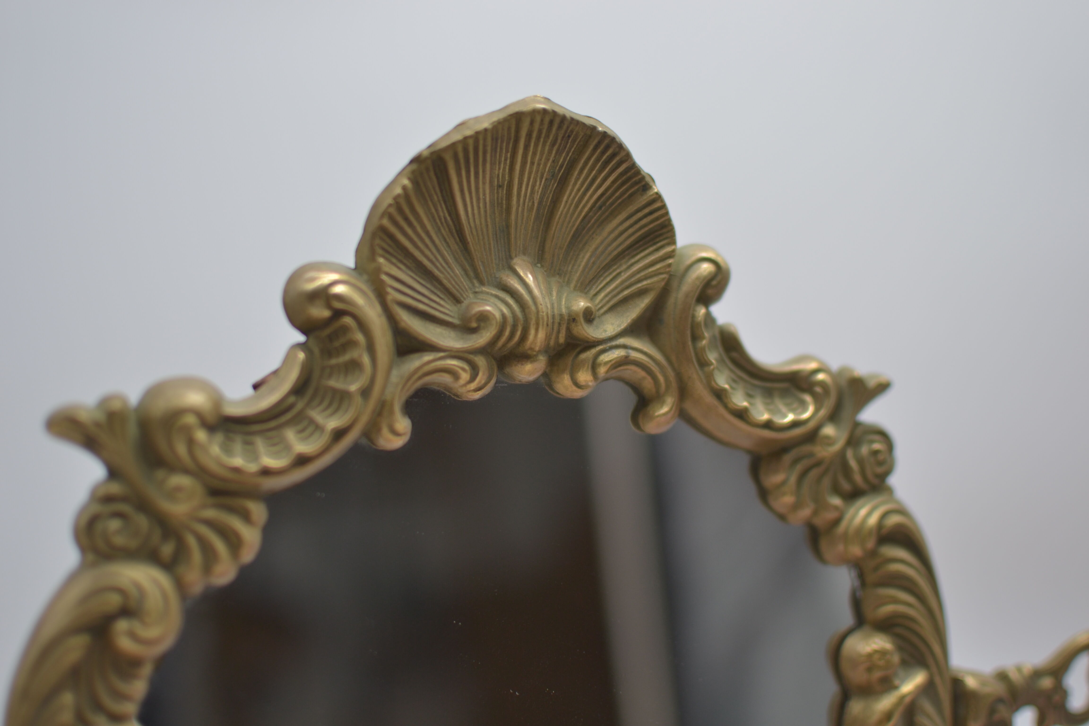 Adjustable psyche mirror of 33 centimeters in gilded bronze with angel ornament