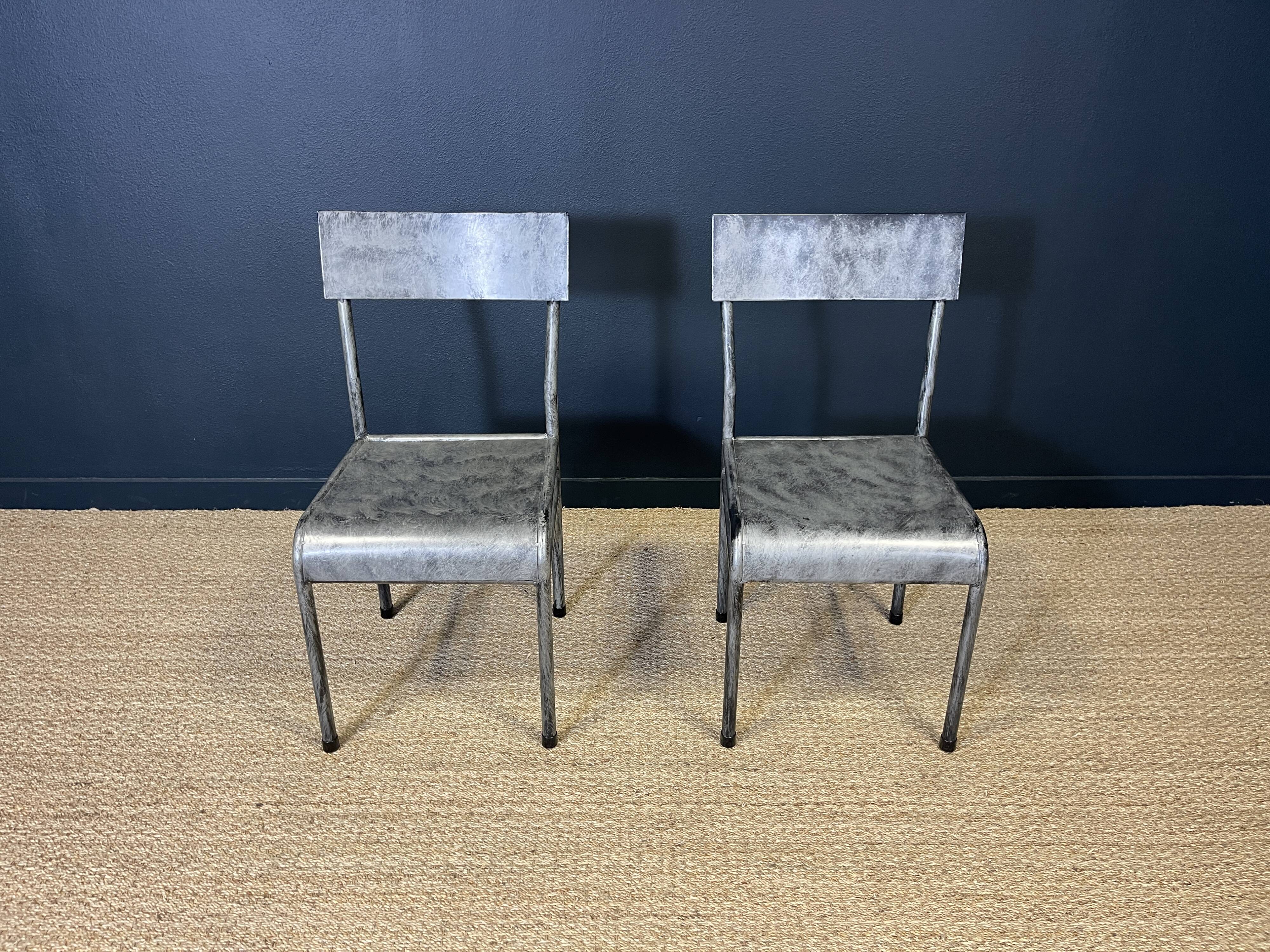 Pair of gray metal industrial chairs