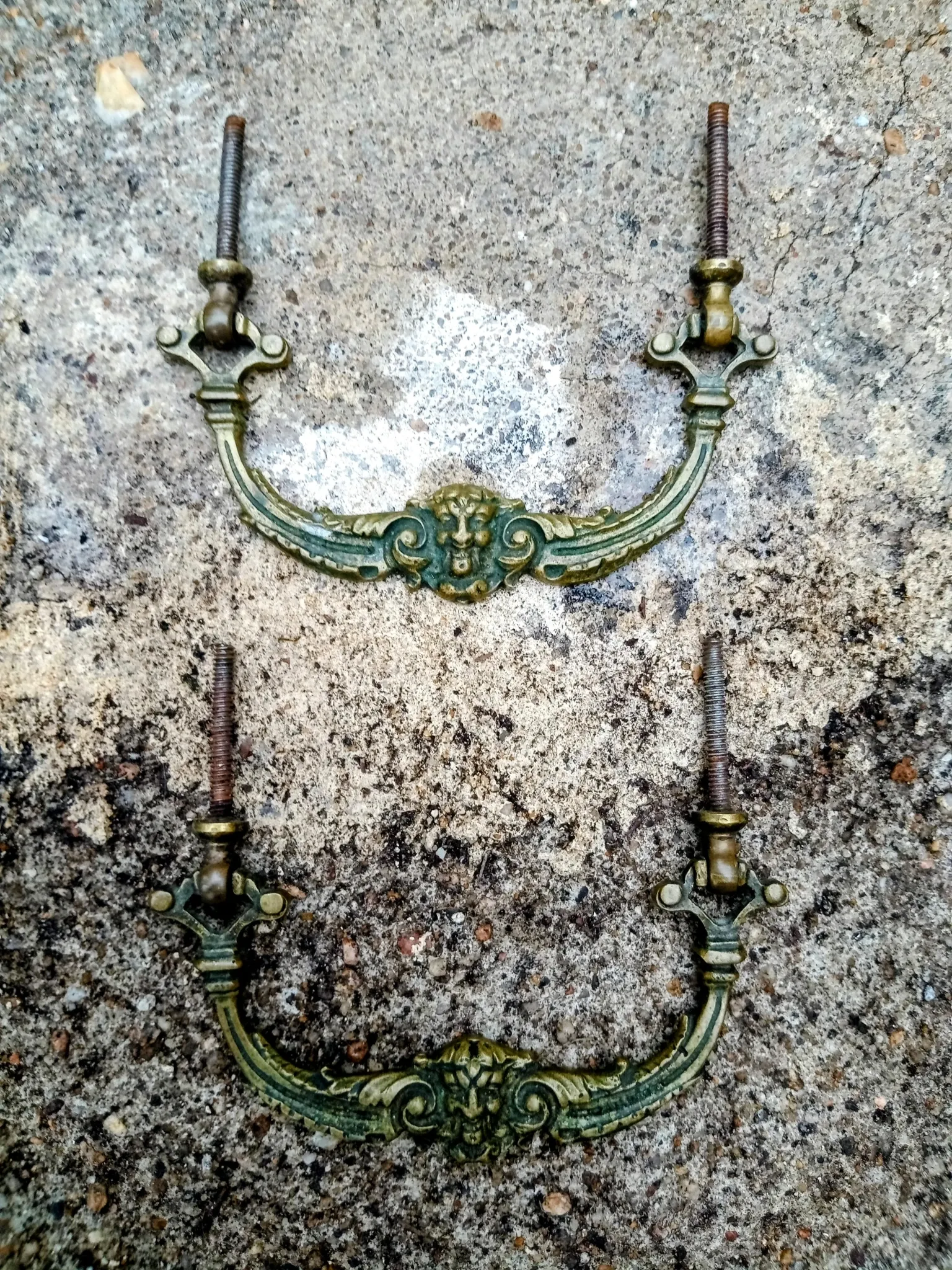 Pair of bronze furniture handles with a mask design, 19th century.