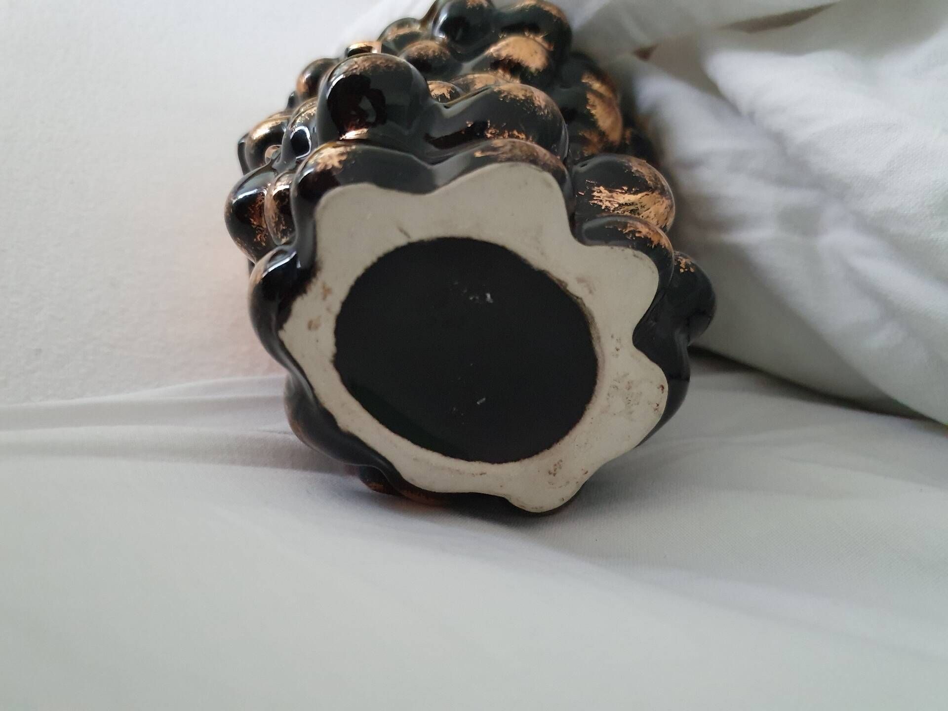 Beautiful black and gold ceramic bottle in the shape of a bunch of grapes.