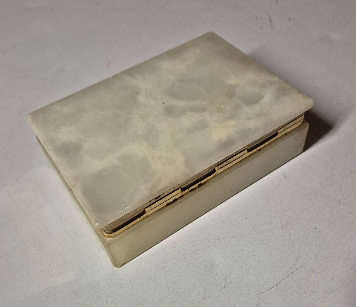 Rectangular light onyx jewellery box with brass trim, empty.