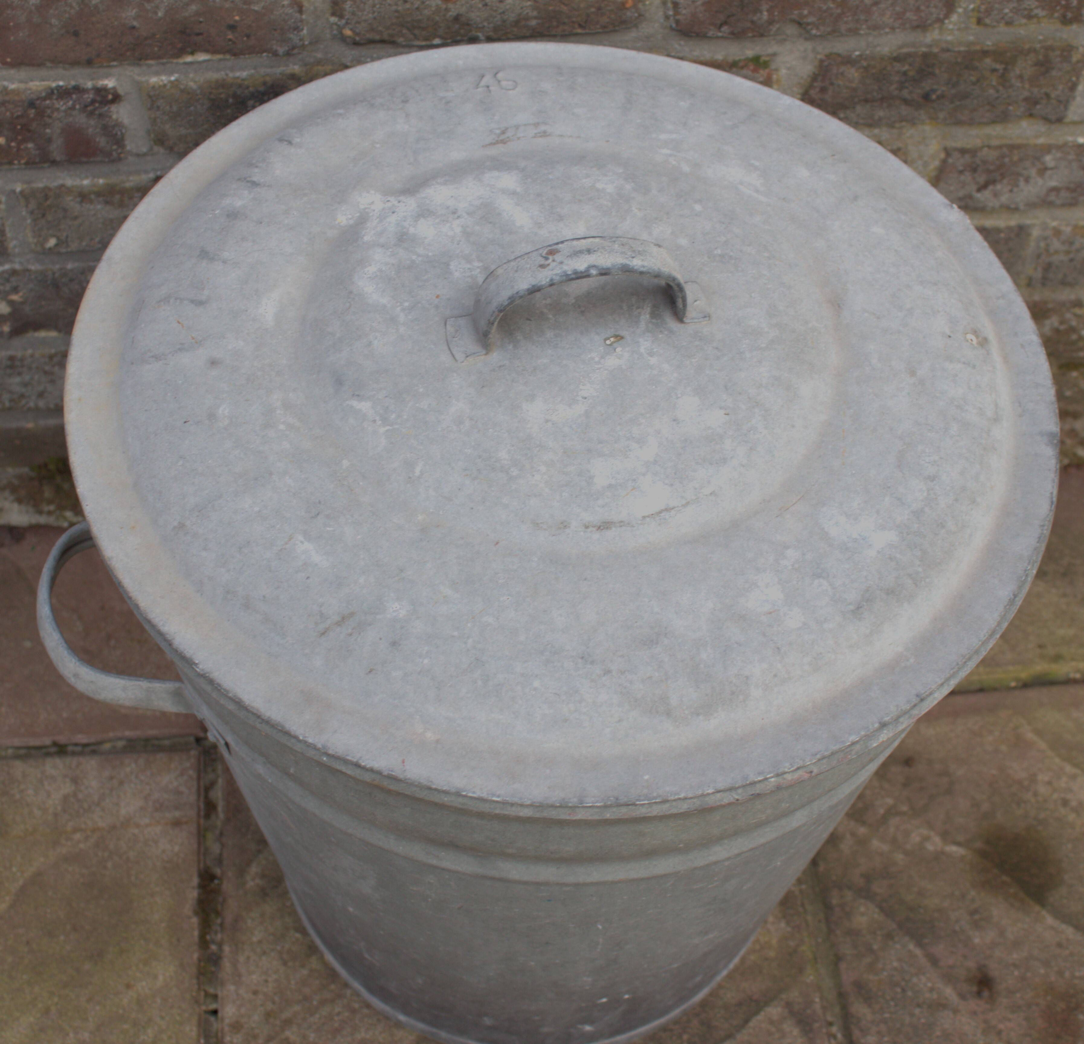 Old galvanized zinc trash can with lid