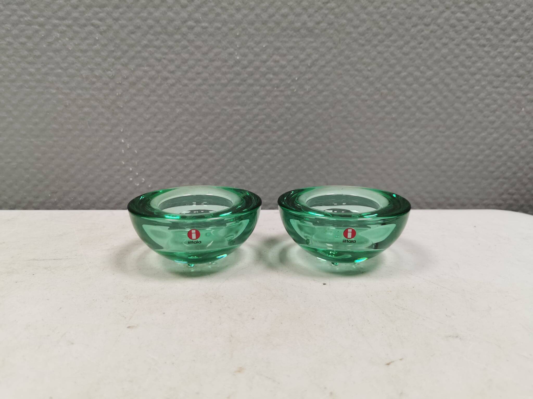A set of iitalla candle holders in green transparent glass.