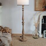 Vintage floor lamp in turned wood with aged effect.