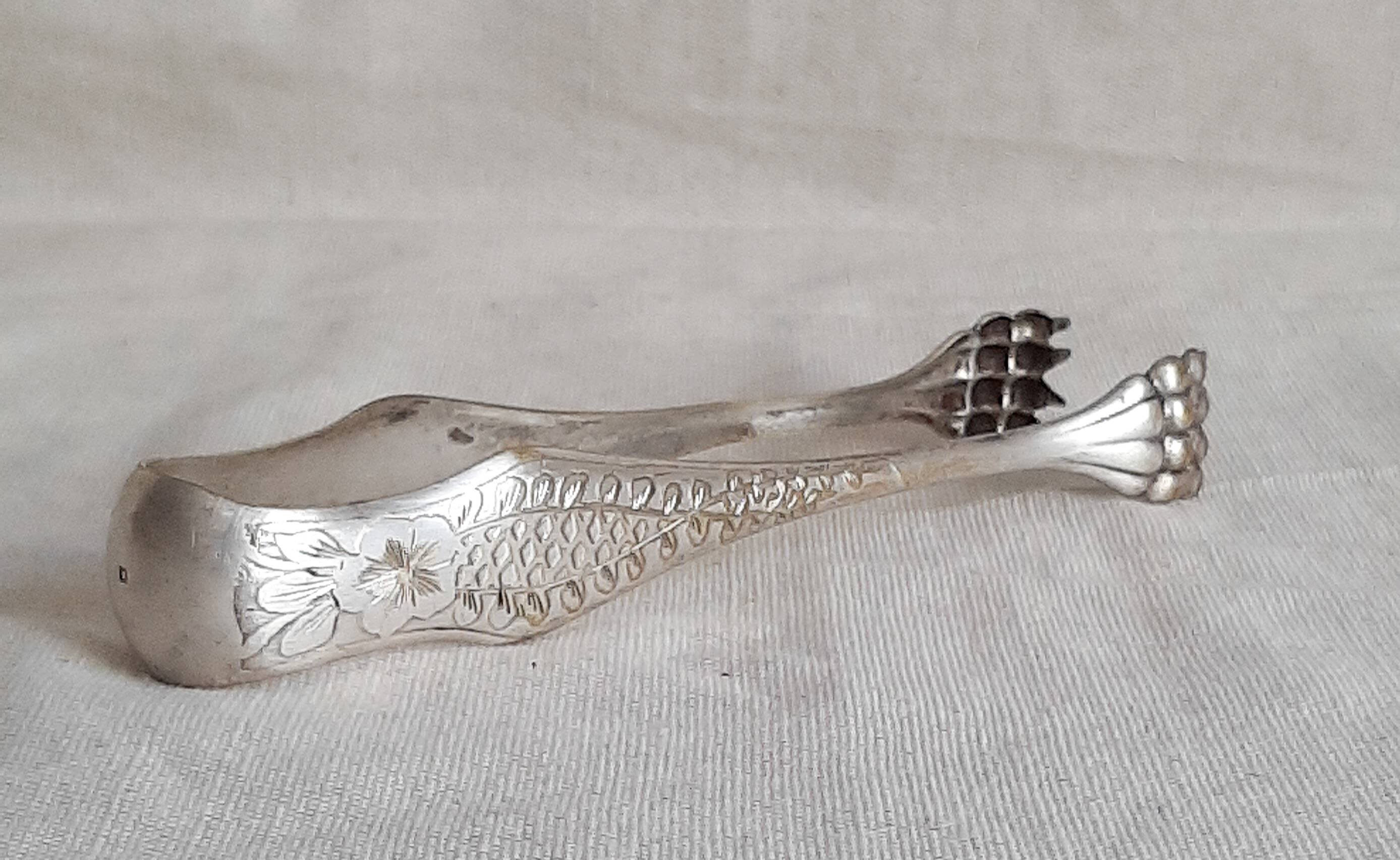 Antique silver-plated sugar tongs with lion's paws.