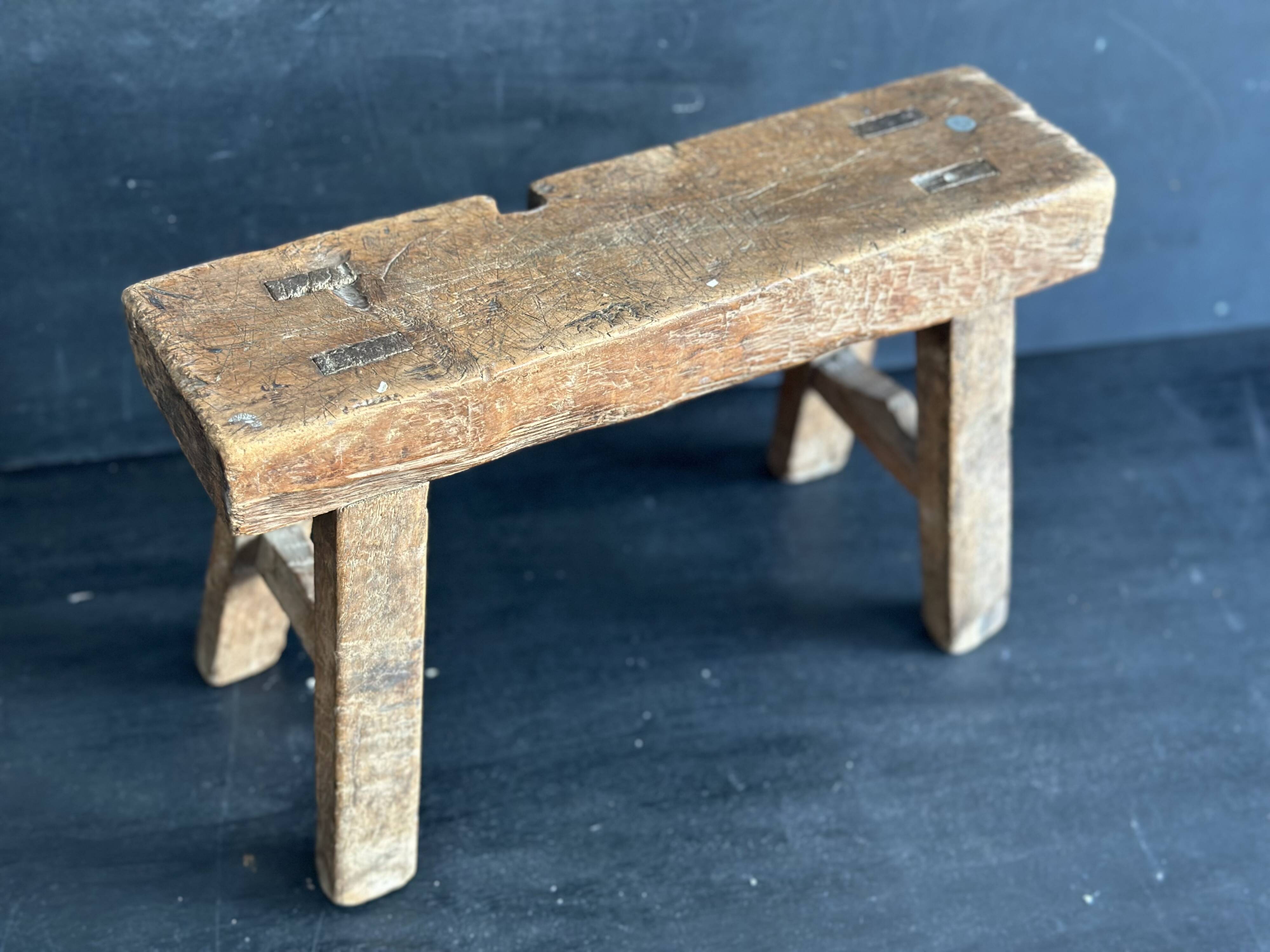 Ancient Chinese farm bench in patinated wood, small rustic stool.