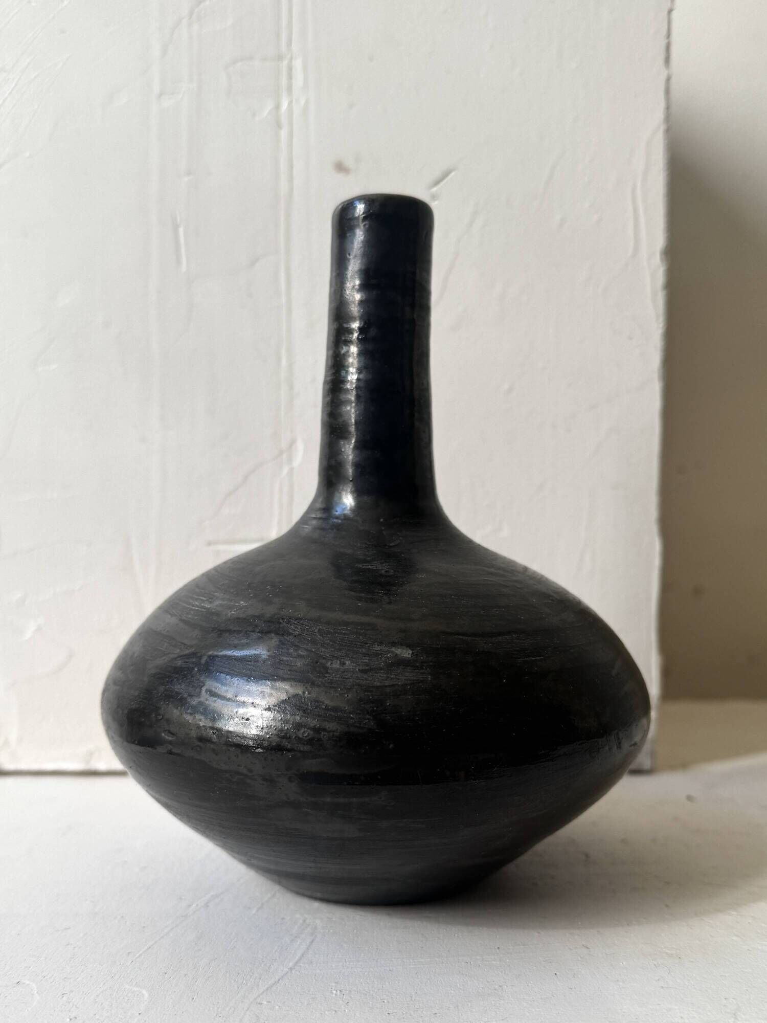 Glazed black ceramic vase with a single stem, signed, circa 1950.