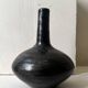 Glazed black ceramic vase with a single stem, signed, circa 1950.