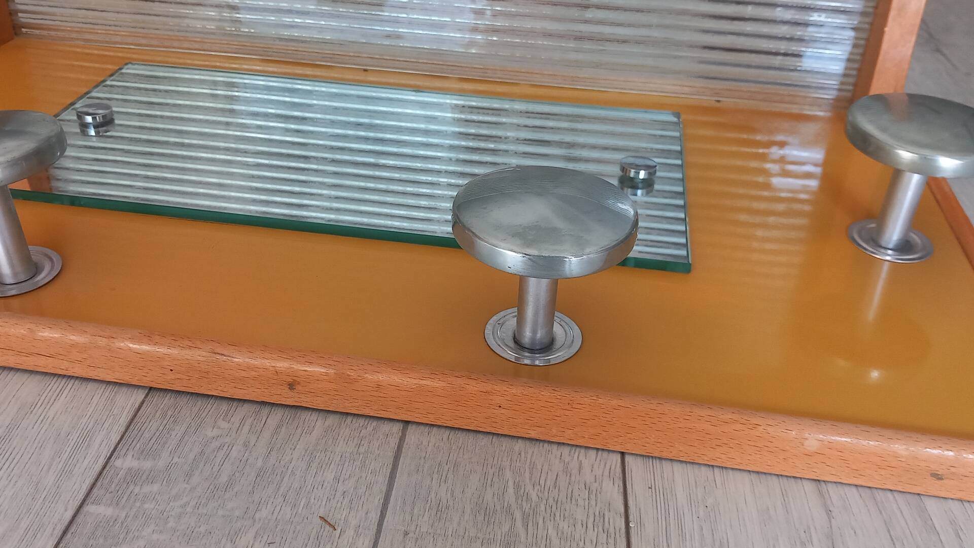 1950s coat rack with mirror, metal hooks, and glass shelf.