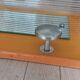 1950s coat rack with mirror, metal hooks, and glass shelf.