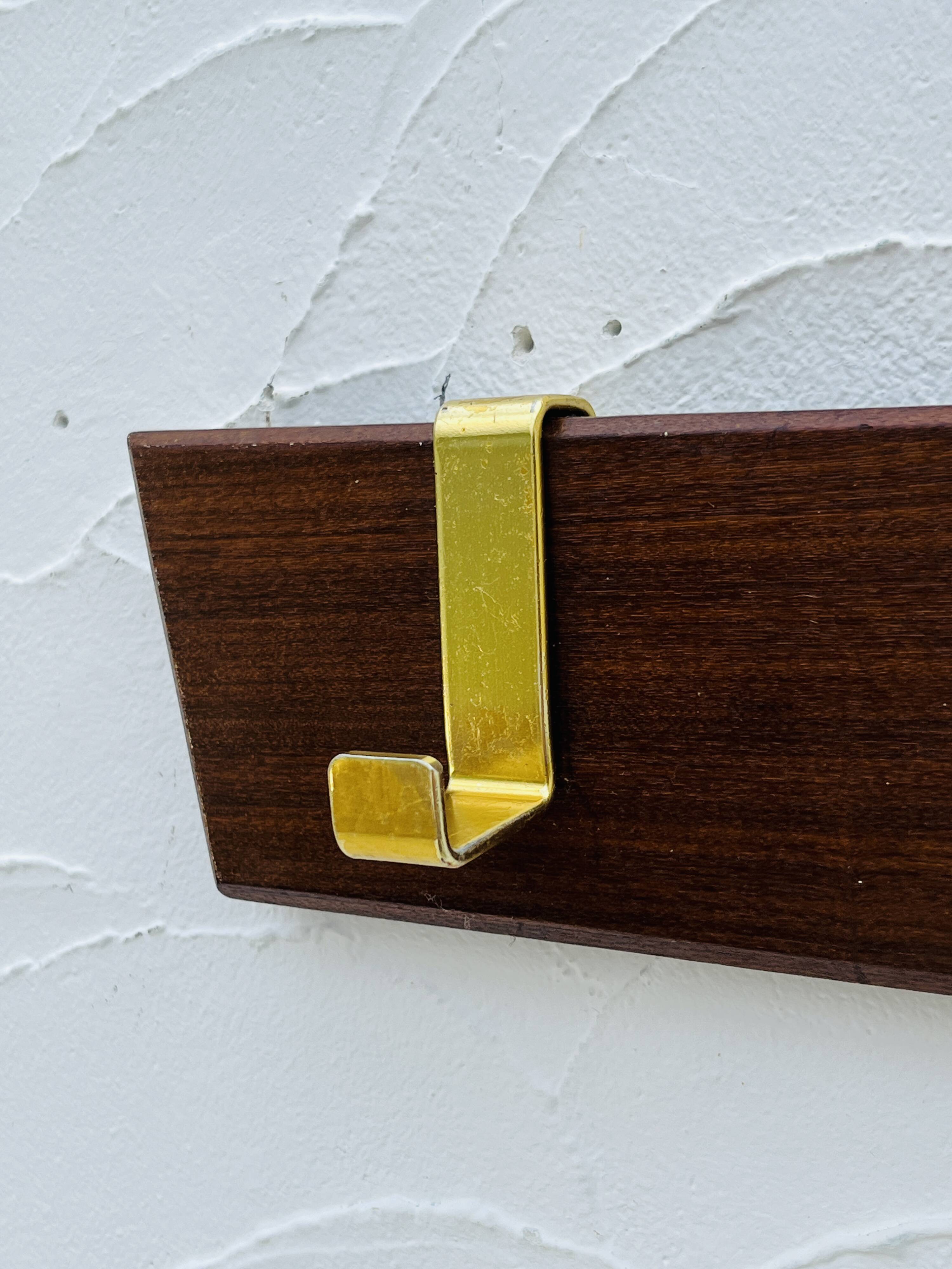 Vintage wooden and brass coat rack with 3 hooks from the 1960s.