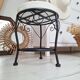 Black iron stool/pouf with its boucle fabric cushion.