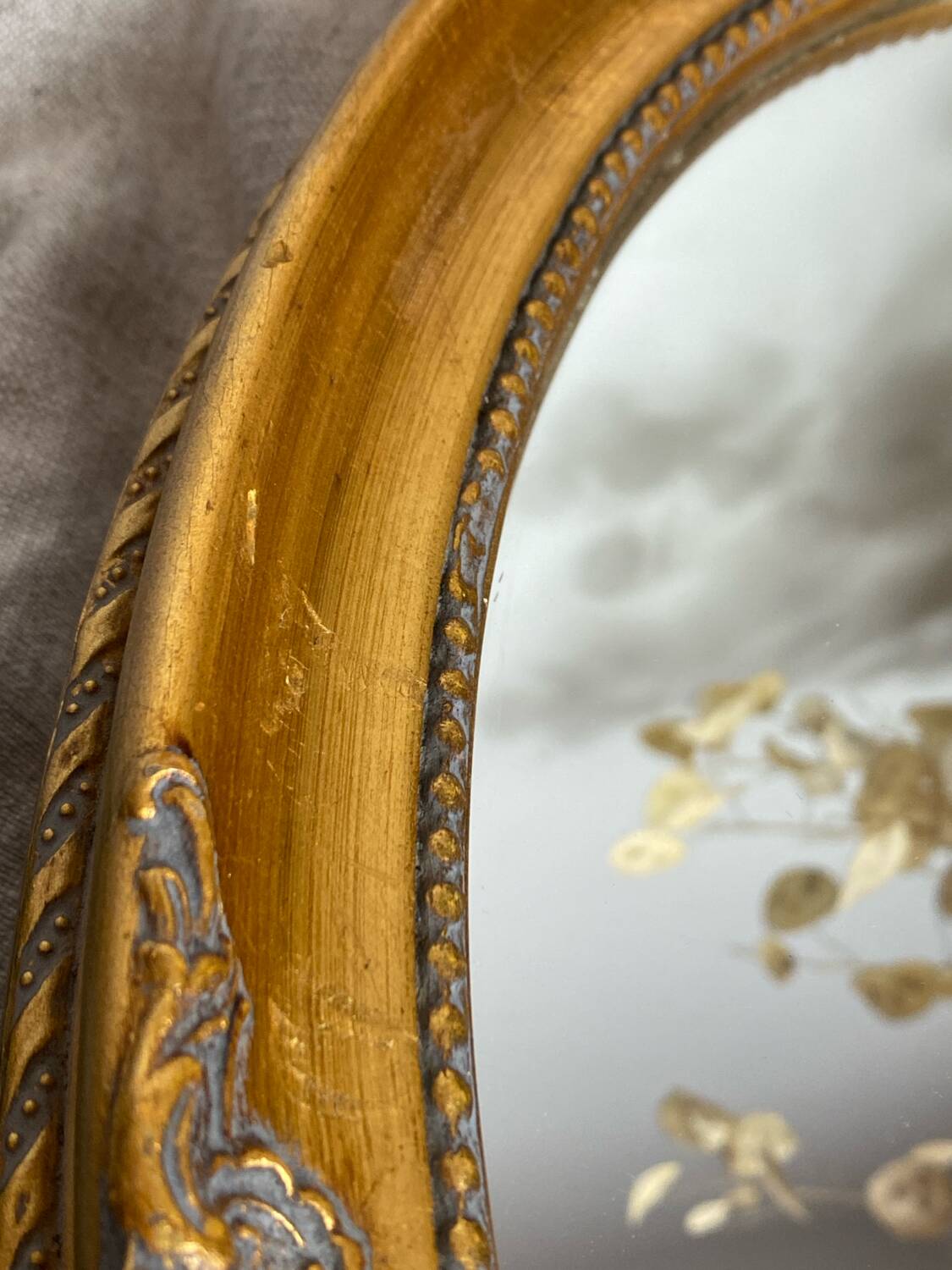 Oval-shaped gilded wooden mirror