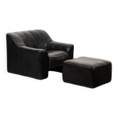 Maison De Sede. Armchair and its ottoman in black leather. 1970s.