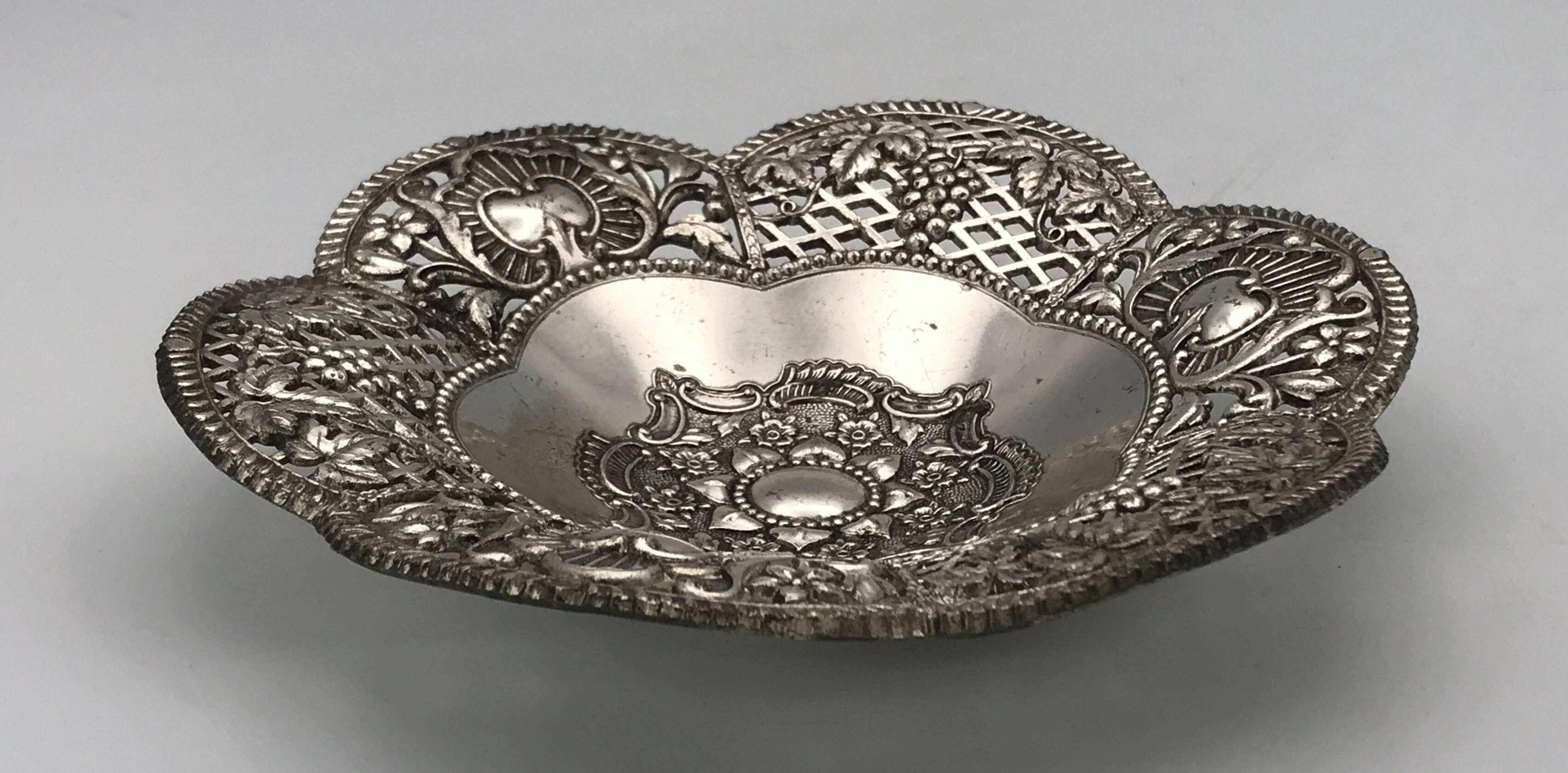 Silver-plated metal pocket emptier with openwork outline decoration