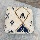 Berber floor pouf: Handwoven Moroccan wool cushion.