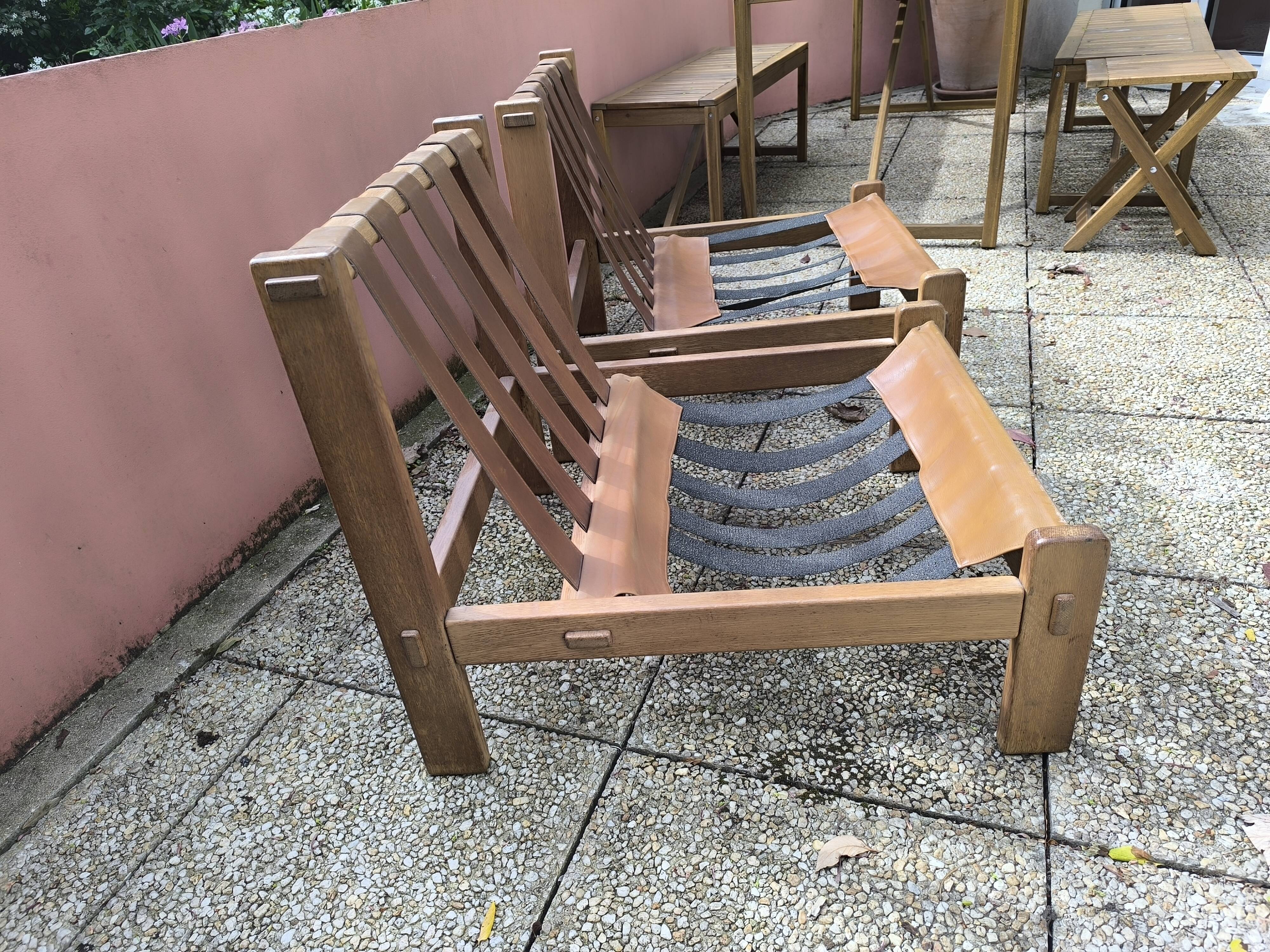 Pair of solid wood and leather lounge chairs, European work, circa 1970.