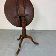 Round coffee table with an adjustable top in antique mahogany.