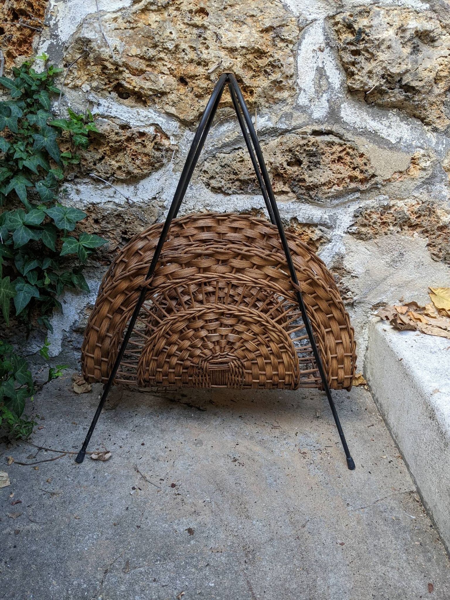 Vintage metal and wicker magazine rack, bohemian country decor.