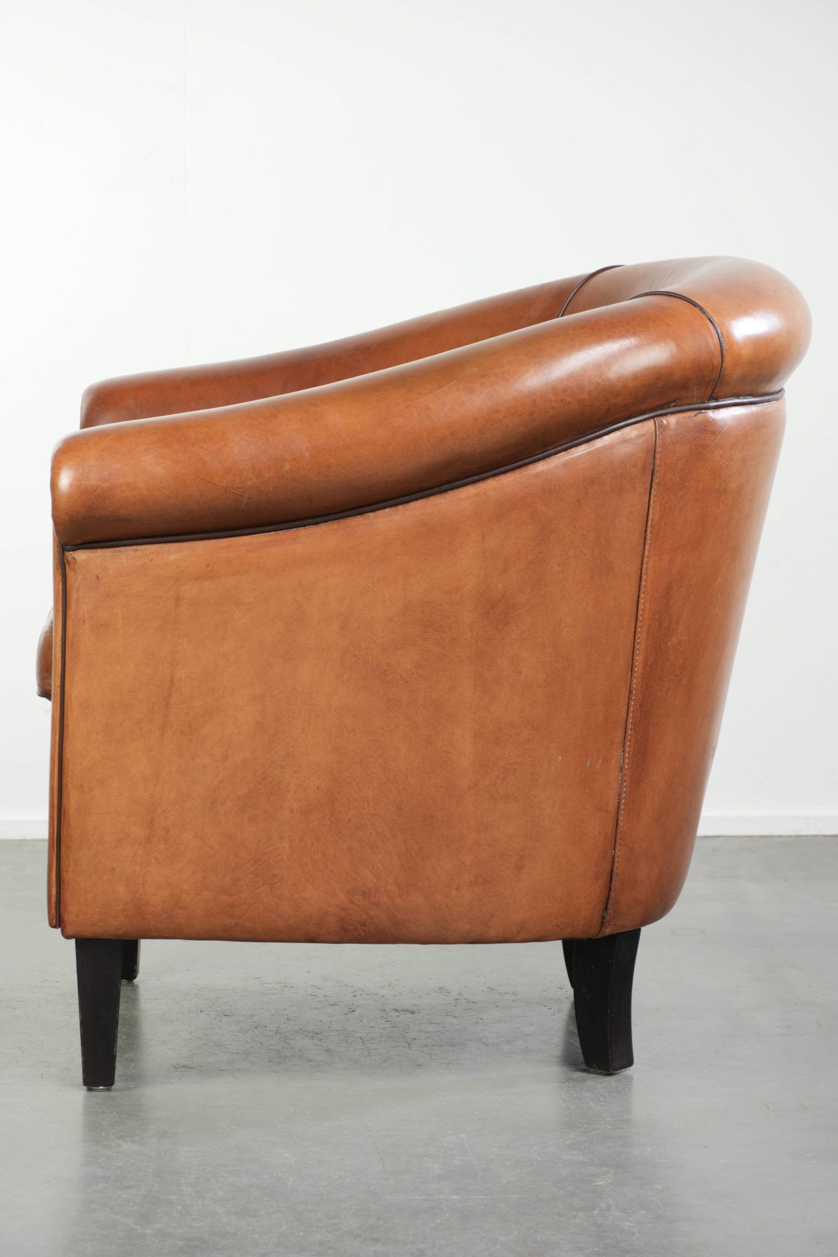 Vintage sheepskin club armchair with a warm colour scheme with black piping
