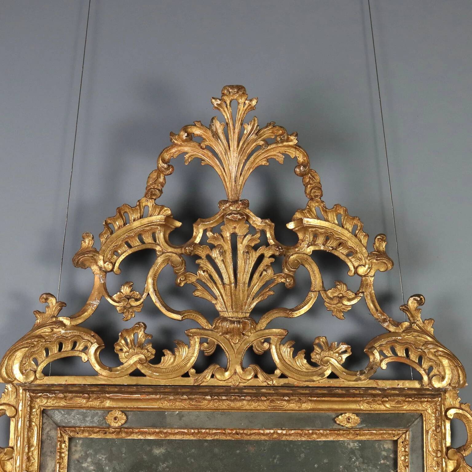 Antique gilded wooden mirror with rococo patterns, Italy, 18th century.