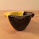 Two-tone ceramic ashtray in yellow and black, vintage 1950s.