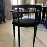 Table de salle à manger noire, en bois, rectangle avec chaises rembourrées.
