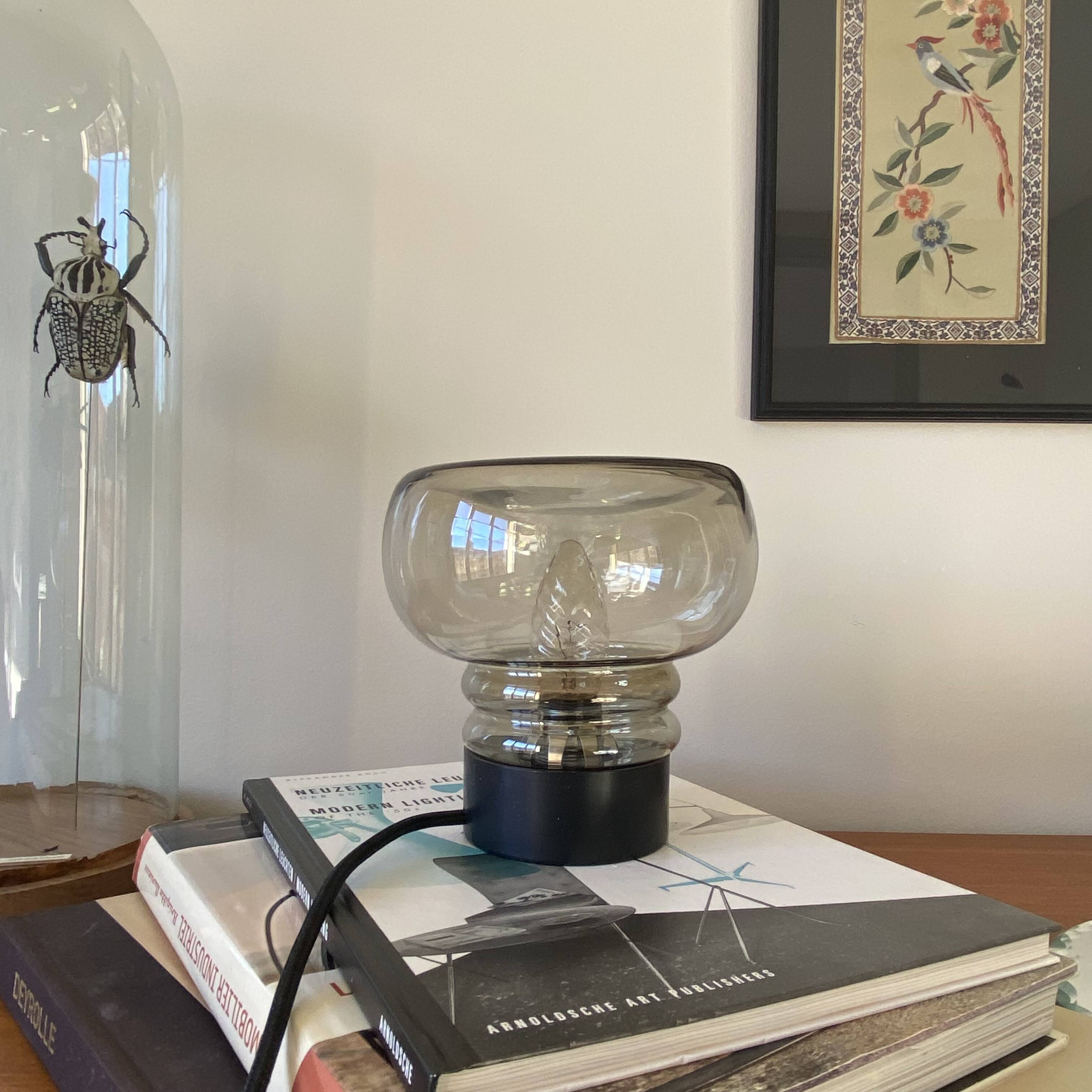 Sciolari table lamp with smoked glass globe and black plastic base.