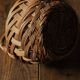 Round woven dark wicker basket with openwork vintage handle