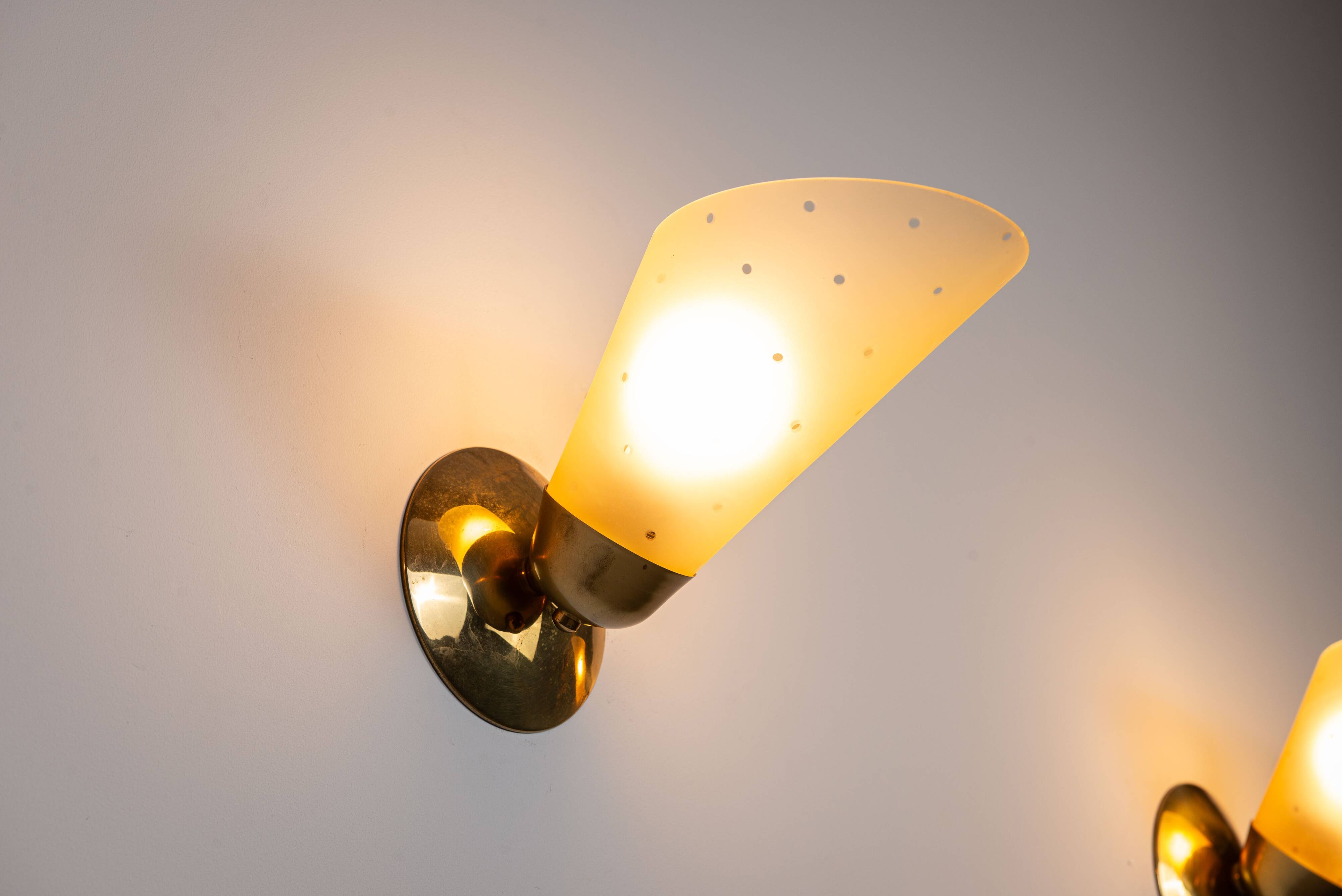 Set of three brass sconces with decorated yellow glass shades
