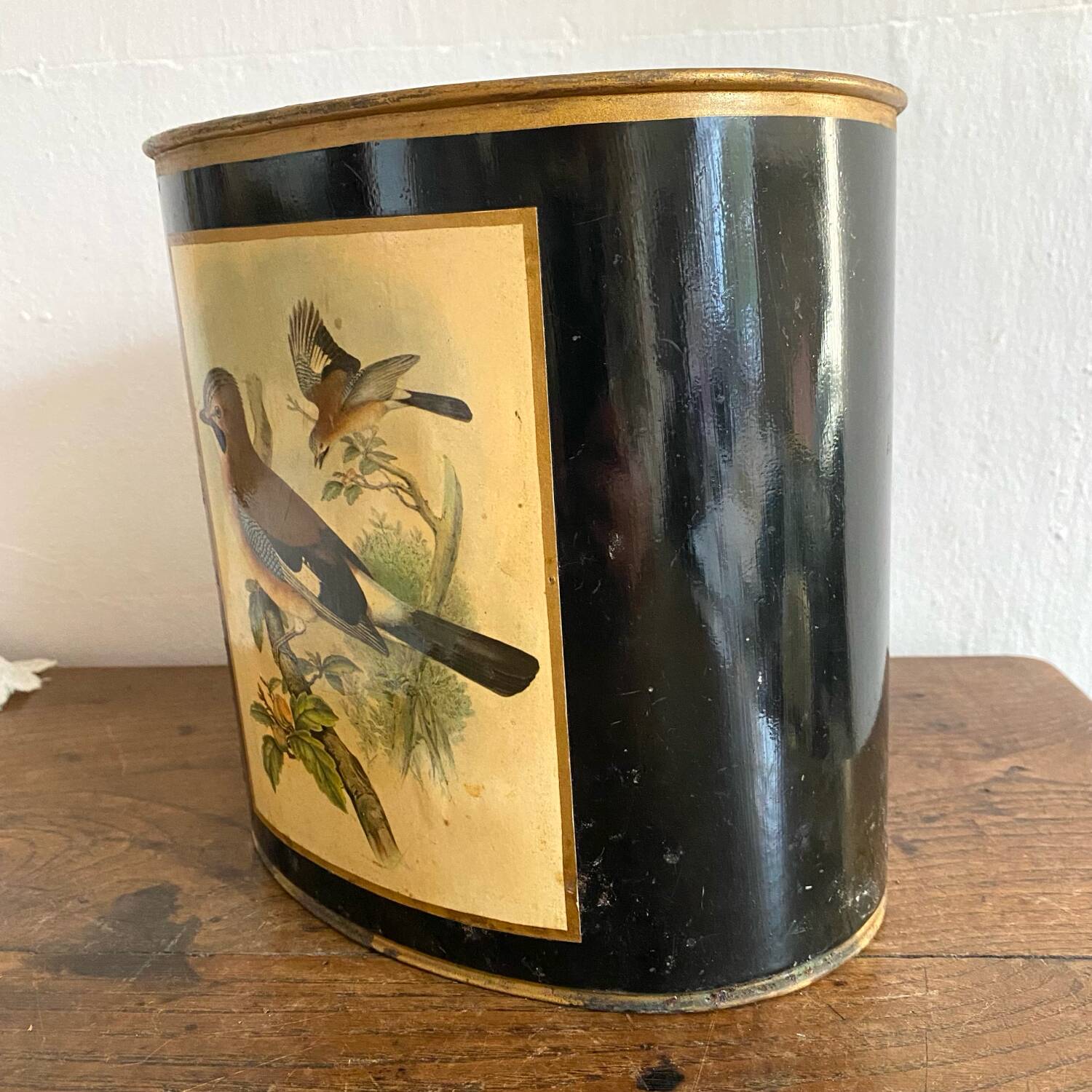 Metal wastebasket with bird decoration