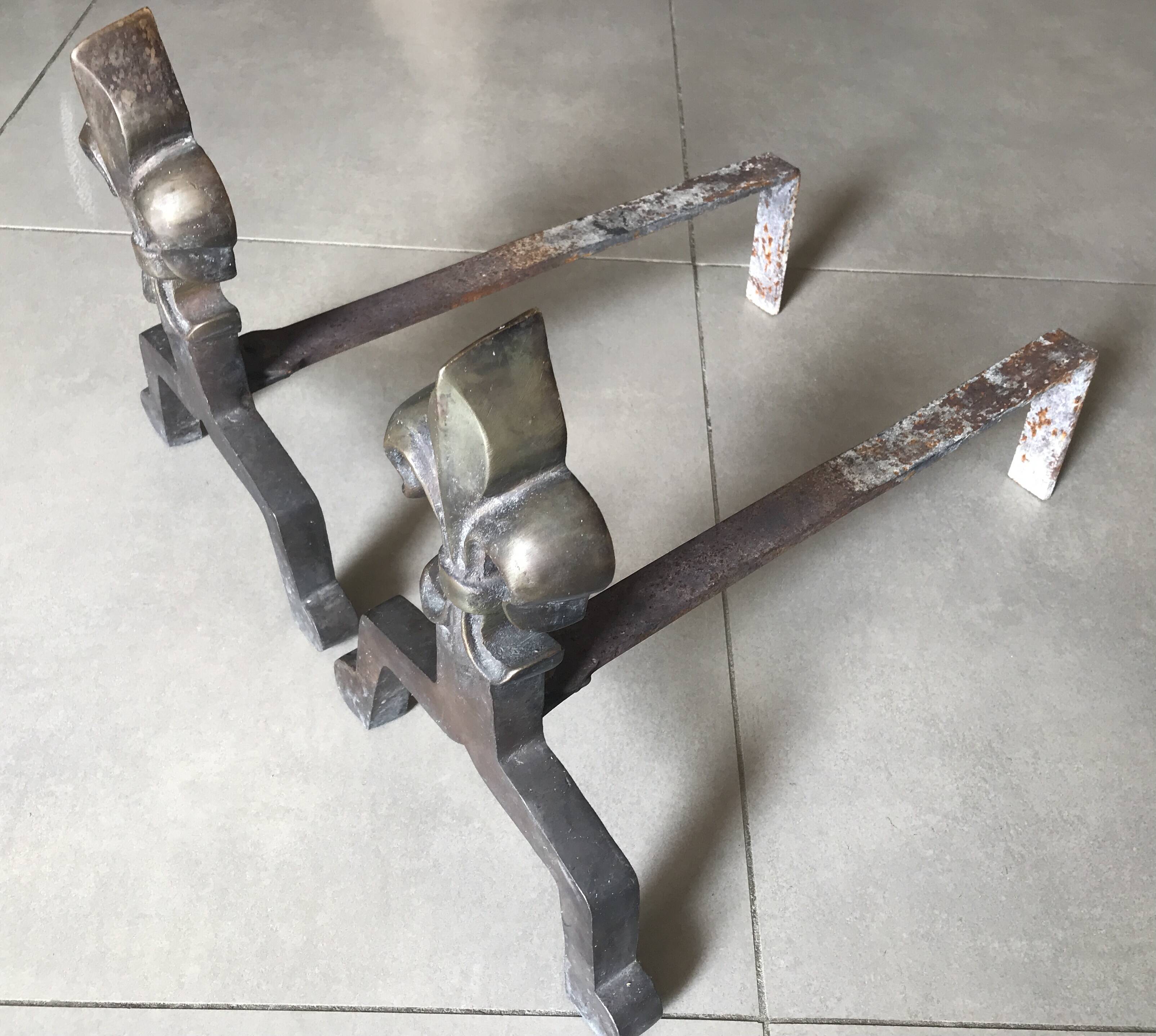 Pair of bronze fireplace firedogs with fleur-de-lys decor, art deco