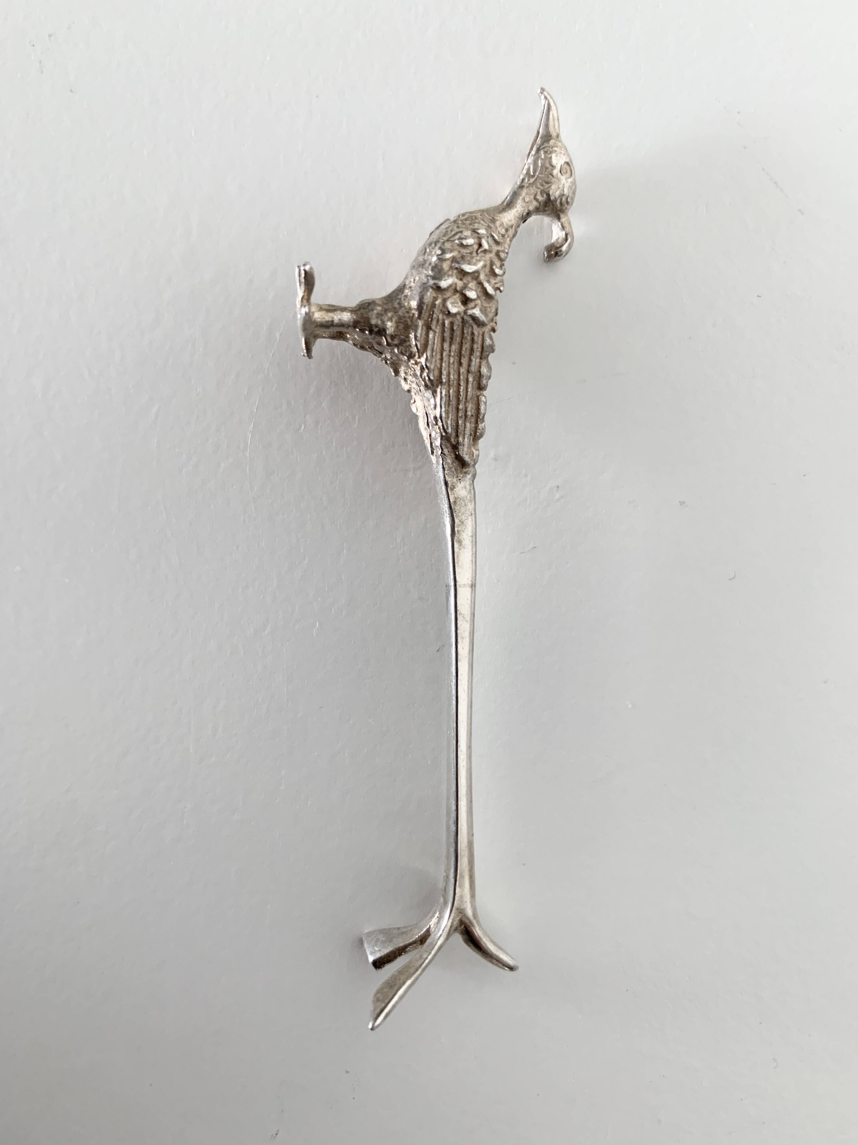 Six silver-plated knife rests in the shape of peacocks.
