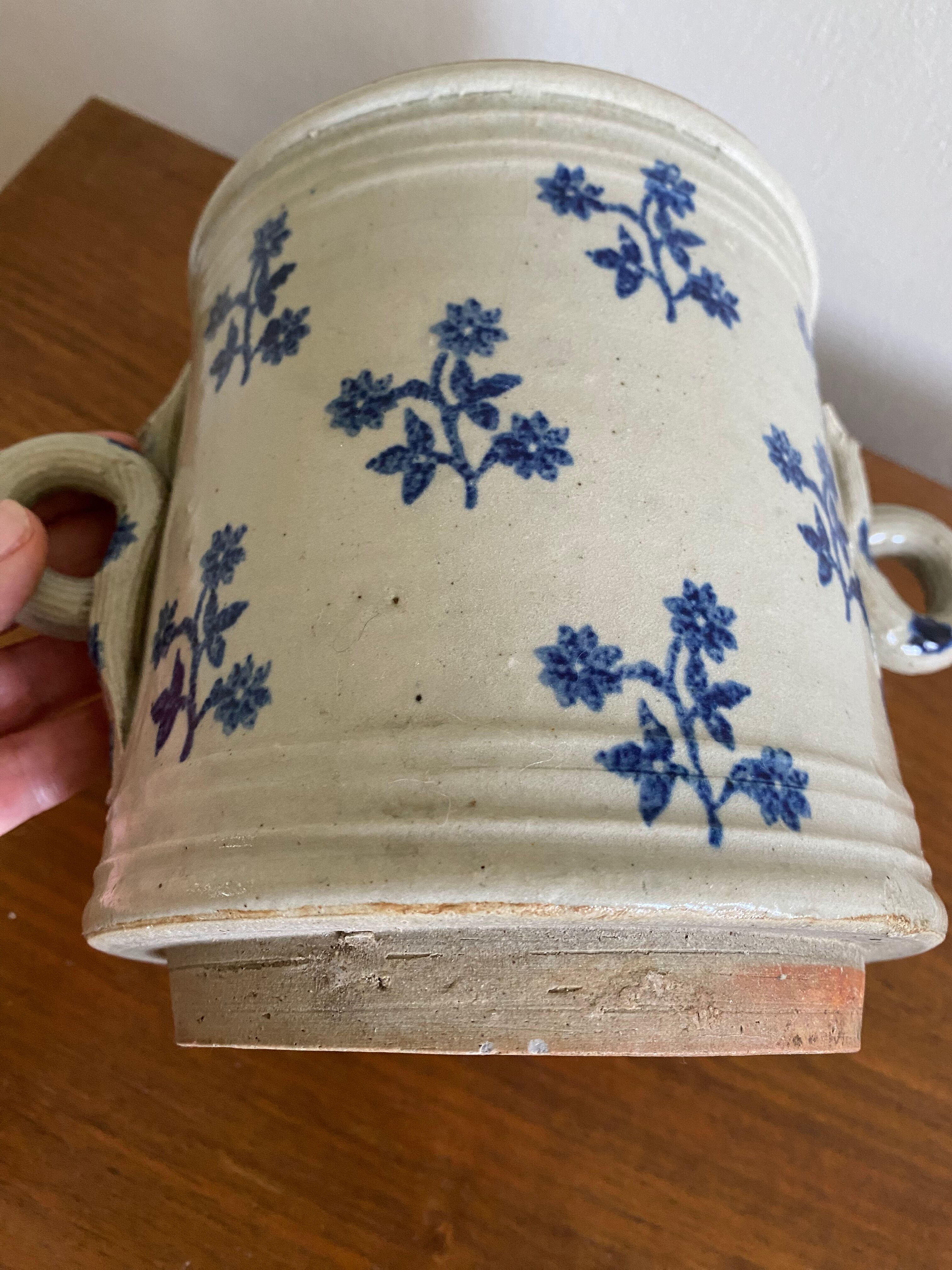 Old pot, sandstone, blue flower decoration