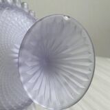 Purple glass pedestal bowl with wavy border and relief pattern.
